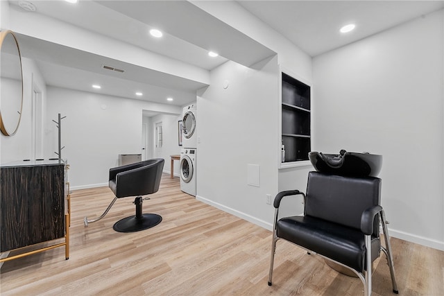 sitting room featuring stacked washer / drying machine, baseboards, visible vents, and light wood finished floors