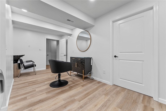 living area featuring visible vents, light wood-style flooring, and baseboards