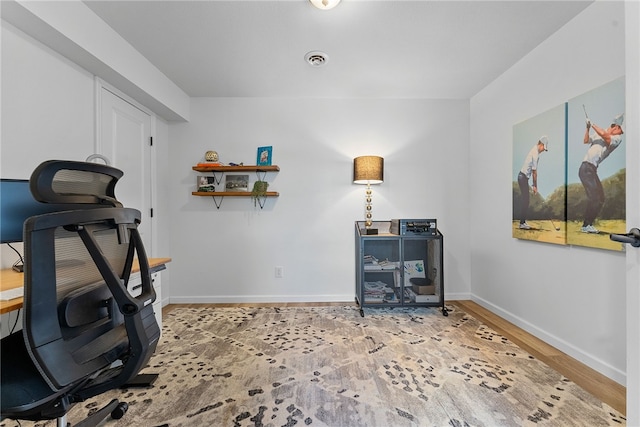 workout room featuring baseboards, visible vents, and wood finished floors