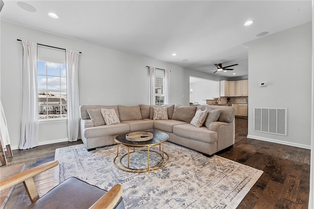 living area featuring baseboards, dark wood-type flooring, visible vents, and recessed lighting