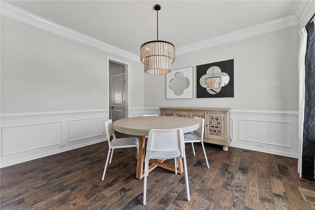 dining area with a chandelier, ornamental molding, dark wood-style flooring, and wainscoting