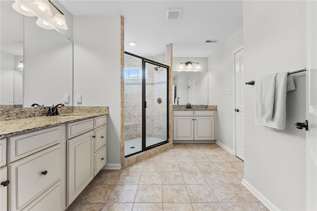 full bath featuring a sink, a stall shower, visible vents, and two vanities