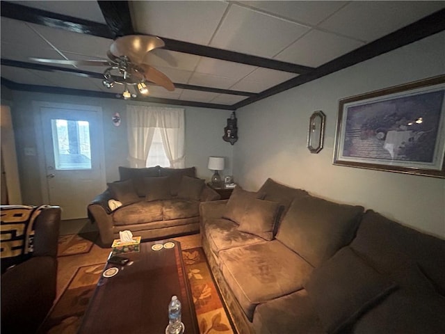 living area featuring a ceiling fan and a drop ceiling