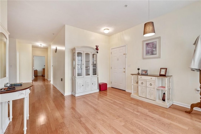 interior space with baseboards and light wood finished floors