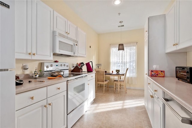 kitchen featuring light countertops, white appliances, and white cabinets