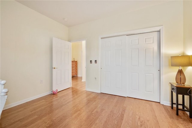 bedroom featuring a closet, light wood-type flooring, and baseboards