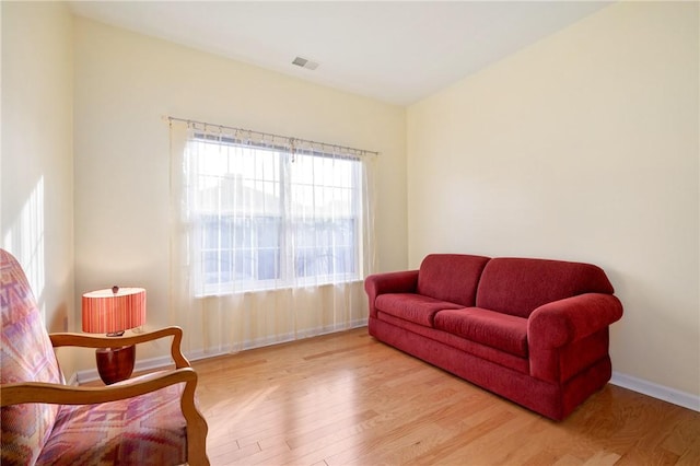 sitting room featuring light wood-type flooring, baseboards, and visible vents