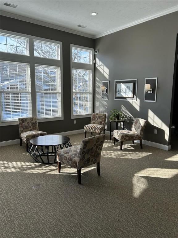 sitting room featuring carpet floors, crown molding, and baseboards