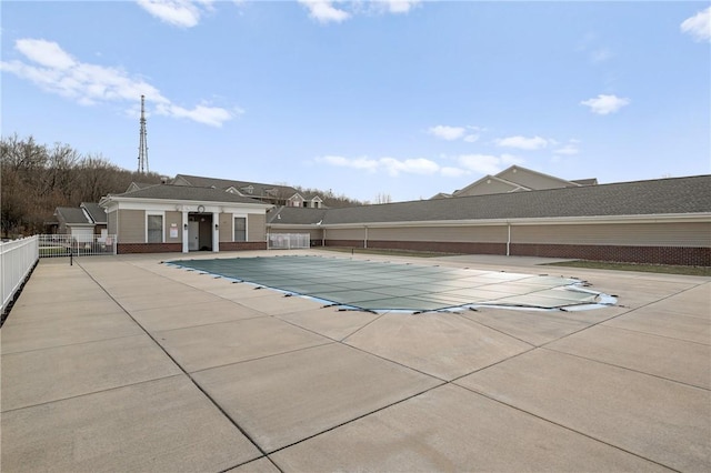 pool with a patio and fence