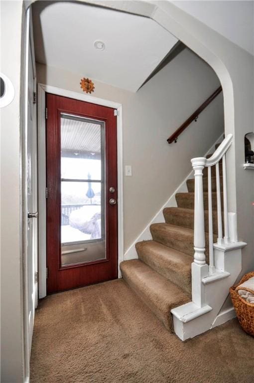 carpeted foyer entrance featuring stairs