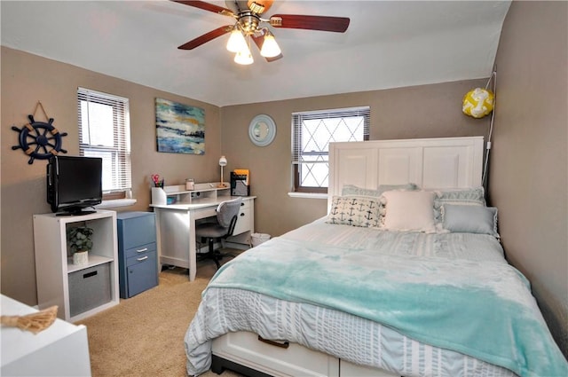 bedroom featuring a ceiling fan, multiple windows, and light carpet