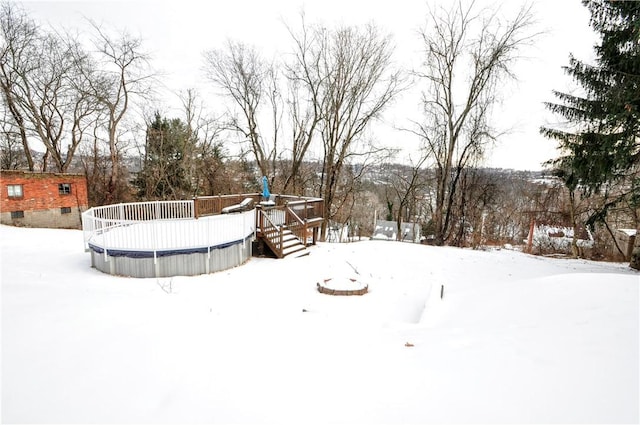 yard covered in snow with a wooden deck