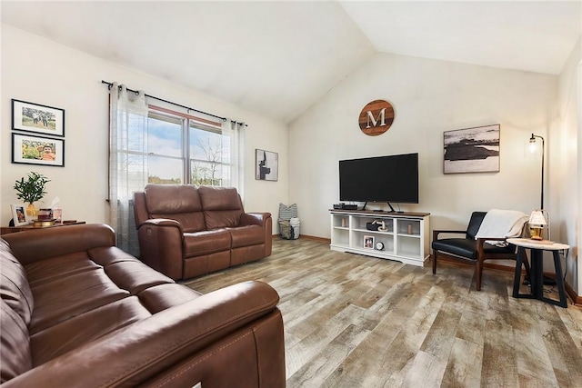 living room featuring light wood-style floors, lofted ceiling, and baseboards