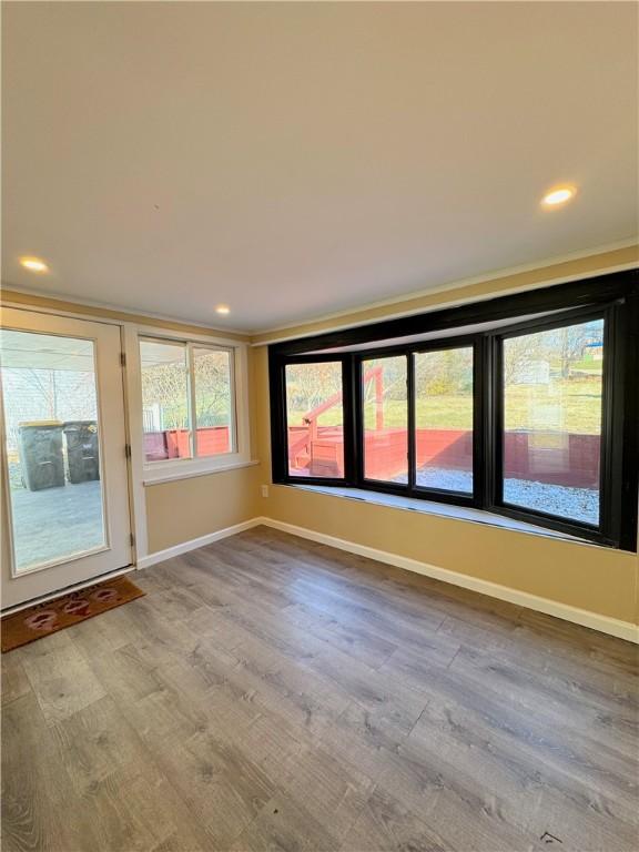 unfurnished room featuring light wood finished floors, recessed lighting, and baseboards