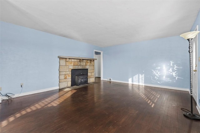 unfurnished living room featuring dark wood-style flooring, visible vents, and baseboards