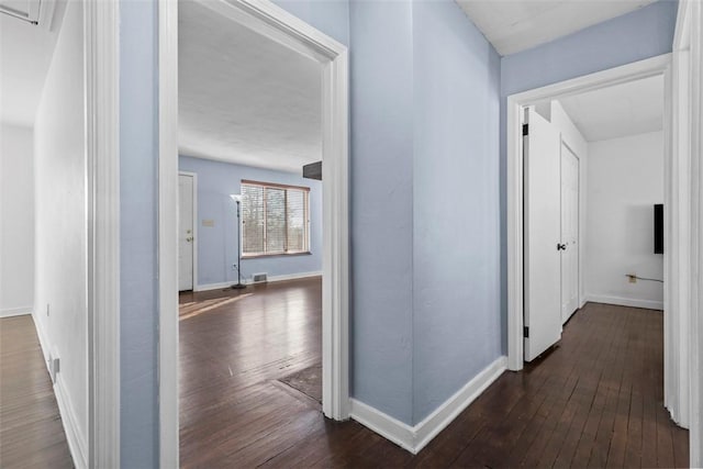 hall featuring dark wood-style floors and baseboards