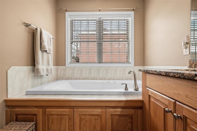 full bath featuring a garden tub and vanity