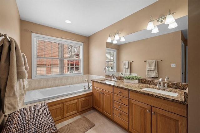 bathroom with double vanity, a garden tub, a sink, and tile patterned floors