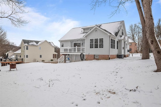 snow covered back of property with a wooden deck and central air condition unit