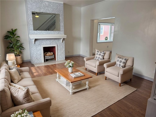 living room with a fireplace, baseboards, and wood finished floors