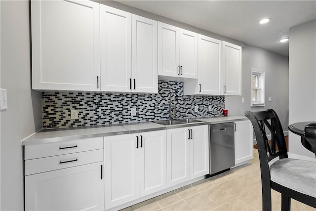 kitchen with light countertops, stainless steel dishwasher, a sink, and white cabinets