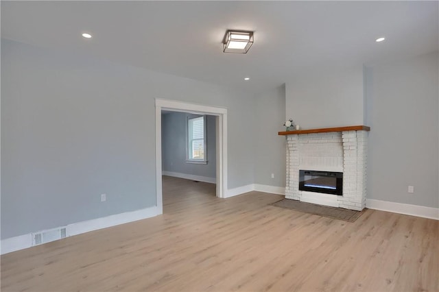 unfurnished living room featuring visible vents, baseboards, light wood-style flooring, a fireplace, and recessed lighting