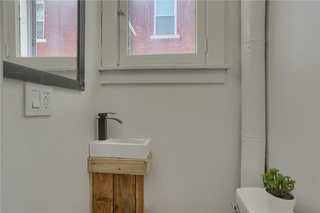 bathroom featuring toilet, a wealth of natural light, and vanity