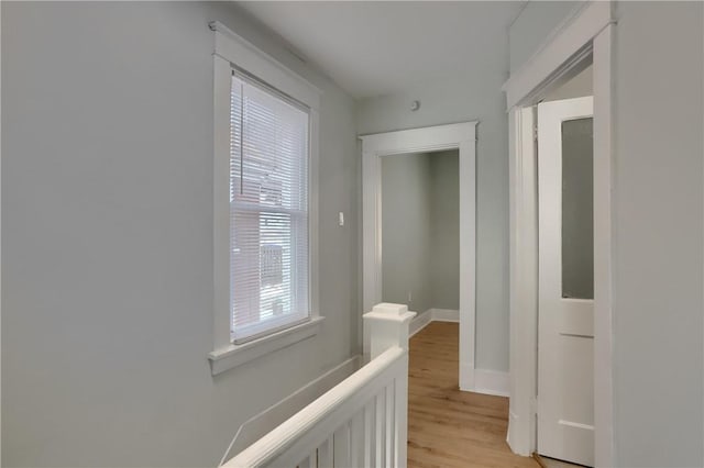 hall with light wood-type flooring and baseboards