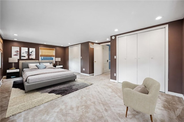 bedroom featuring baseboards, recessed lighting, two closets, and light colored carpet