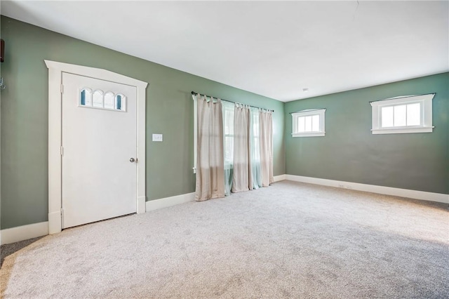 foyer entrance featuring carpet floors and baseboards