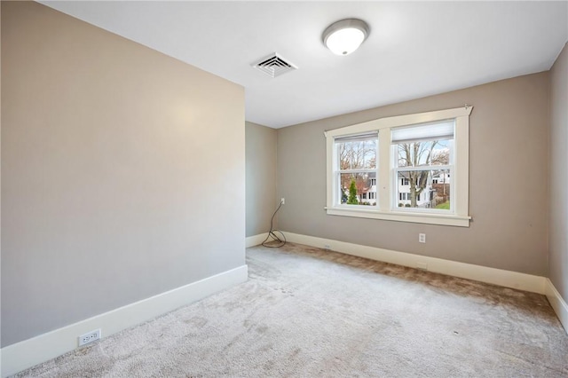 carpeted spare room featuring visible vents and baseboards