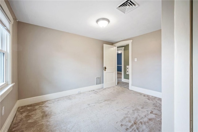 carpeted spare room with visible vents and baseboards