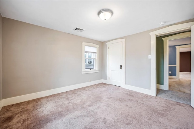 unfurnished bedroom featuring baseboards, visible vents, and light colored carpet