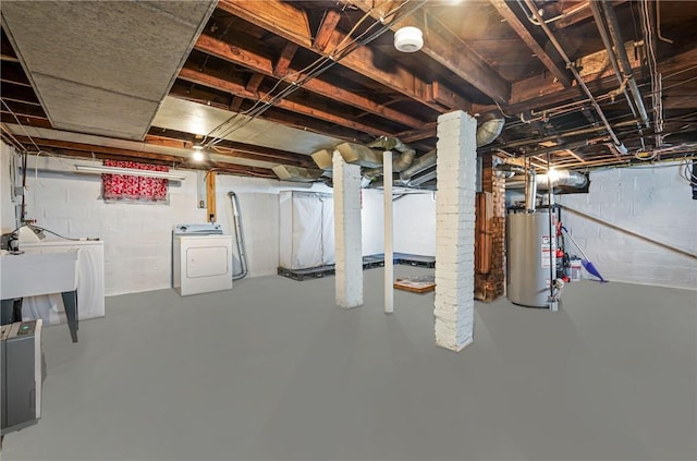 unfinished basement featuring washer and dryer, gas water heater, and a sink