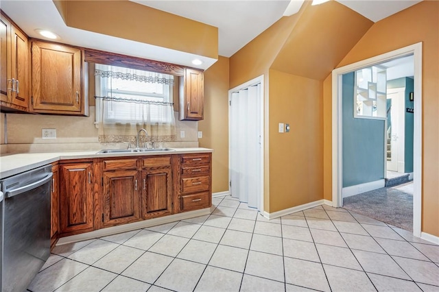 kitchen featuring light countertops, brown cabinets, dishwasher, and a sink