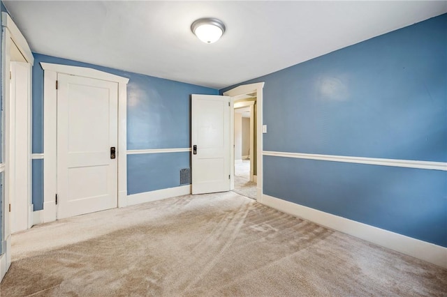 carpeted empty room featuring baseboards and visible vents