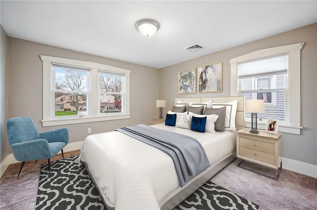 carpeted bedroom featuring baseboards and visible vents