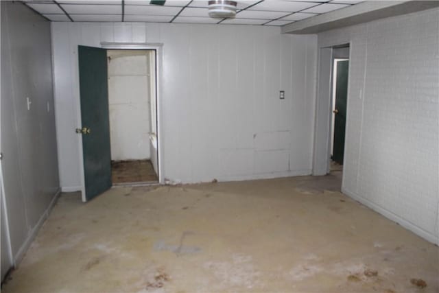 spare room with concrete flooring and a drop ceiling