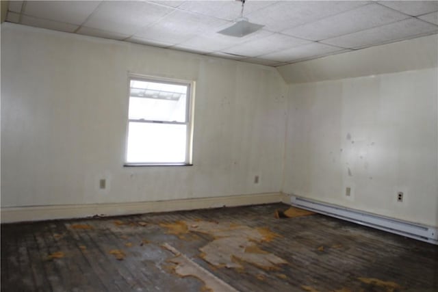 unfurnished room featuring vaulted ceiling, a drop ceiling, dark wood-type flooring, and a baseboard radiator