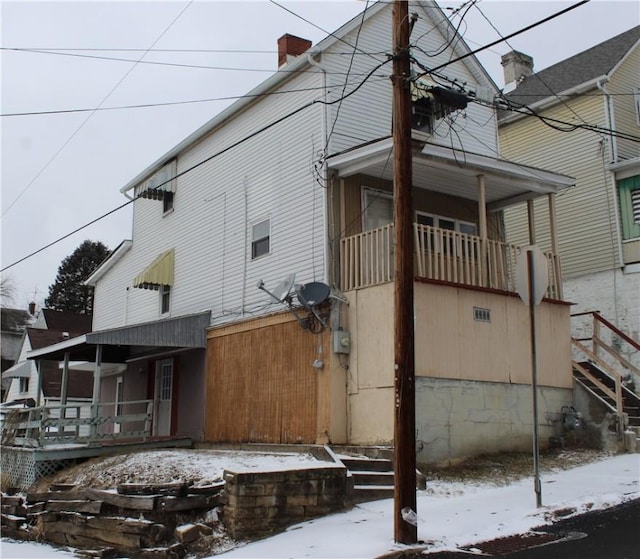 view of snowy exterior featuring a chimney