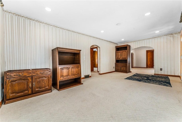 living room featuring arched walkways, recessed lighting, baseboards, and wallpapered walls