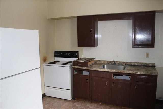 kitchen featuring dark countertops, white appliances, a sink, and dark brown cabinetry