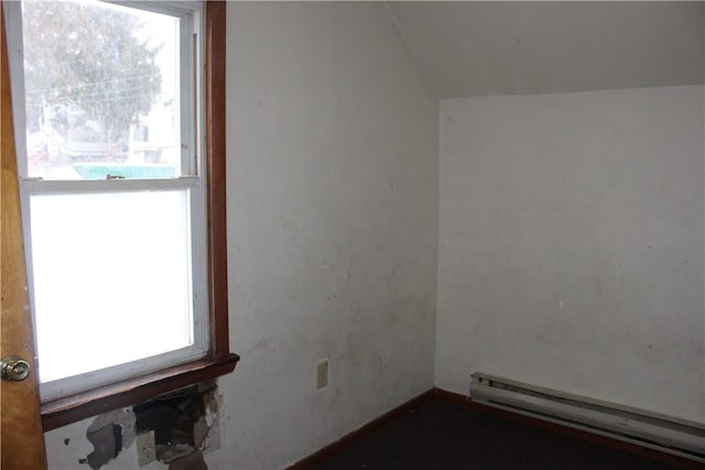 empty room with a baseboard radiator and lofted ceiling