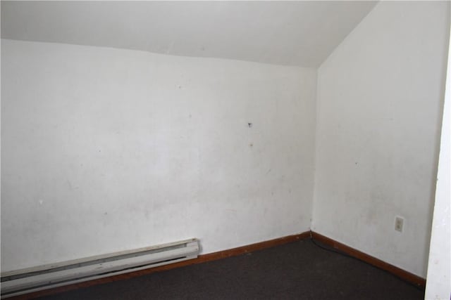 empty room with lofted ceiling, baseboard heating, and baseboards