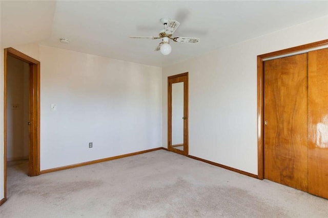 empty room featuring light carpet, ceiling fan, and baseboards