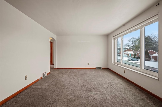 unfurnished room featuring baseboards, visible vents, and carpet flooring