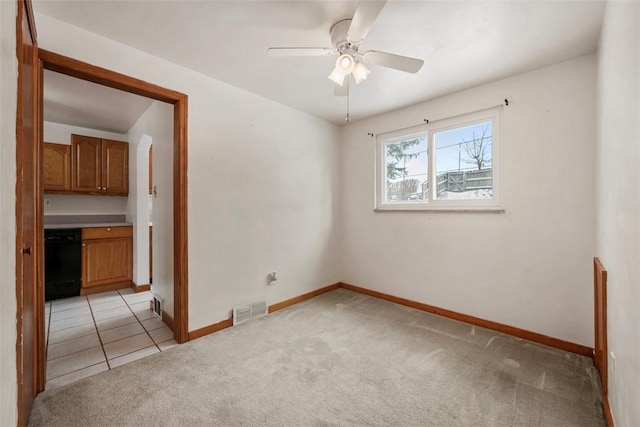 spare room with light carpet, baseboards, visible vents, and a ceiling fan