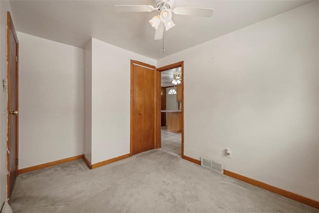 empty room featuring light carpet, visible vents, and baseboards