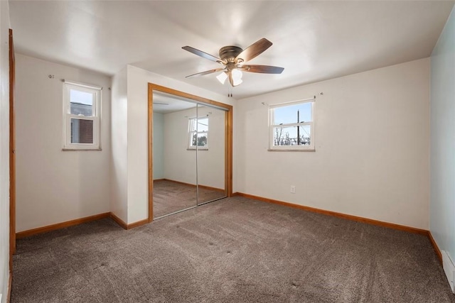 unfurnished bedroom featuring a ceiling fan, a closet, carpet flooring, and baseboards