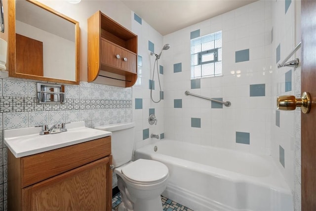 bathroom with toilet, vanity, tile walls, shower / washtub combination, and decorative backsplash